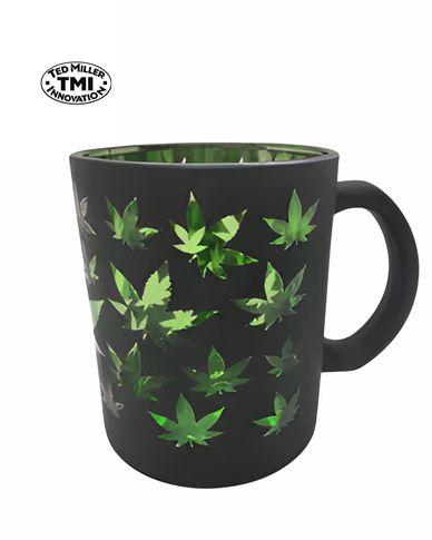 Black mug with shiny green leaf cutouts and handle.