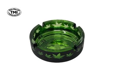 Green glass ashtray decorated with cannabis leaf patterns.