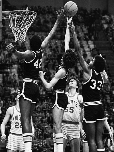 Vintage basketball game with players contesting a shot.