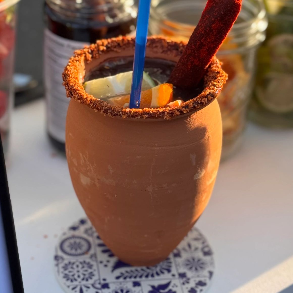 Cantarito with a tamarindo stick on a ceramic coaster