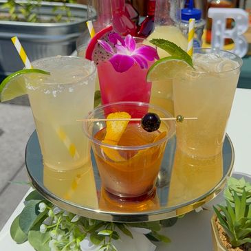 Cocktails neatly displayed on a cake stand; margarita, old fashioned, Moscow mule, and a dragon frui