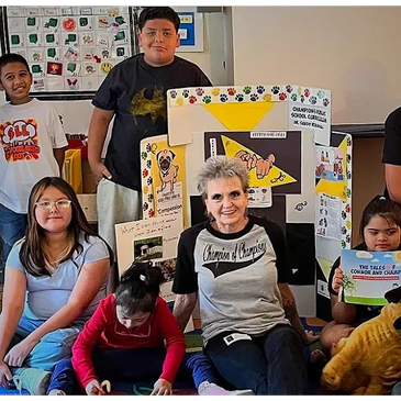 Group of children and an adult with educational display.