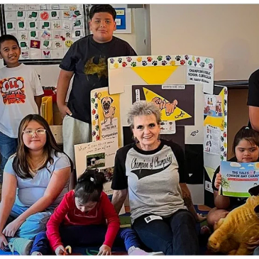 Group of children and an adult with educational display.