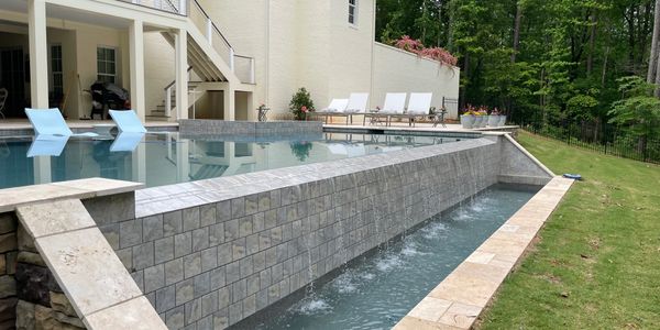 Luxury custom gunite swimming pool built by JP Pools in Jackson County, Georgia featuring natural stone coping, elegant water features, and a spacious backyard design.