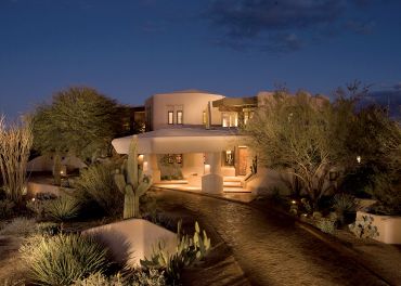 A desert-style house illuminated at night.