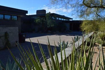 Modern house with desert landscaping under a blue sky.