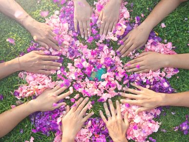 hands in a circle with Rose petals
