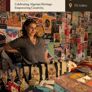 Woman standing behind a craft display celebrating Algerian heritage.