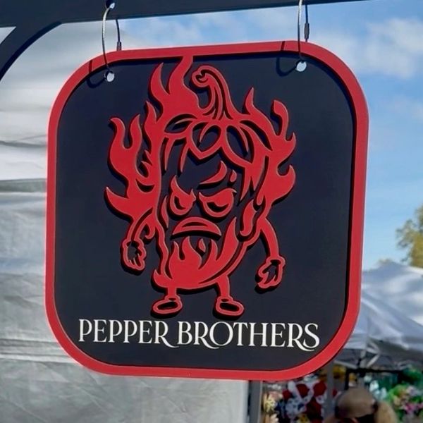 Signboard of Pepper Brothers with a fiery chili character.