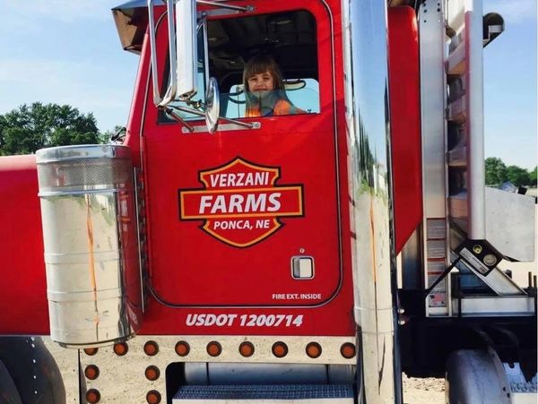 Young child sitting inside a red VerZani Farms truck in Ponca, NE.