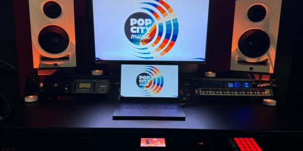 Music production studio setup with speakers and laptop.