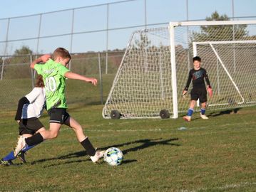 Young soccer player taking a shot at goal.