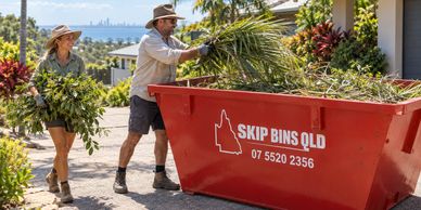Garden prunings being loaded into a red Skip Bins QLD bin. Illustrative image.