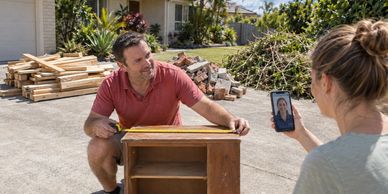 Illustrative Brisbane clean-up planning scene: measuring furniture, consulting an adviser and keepin