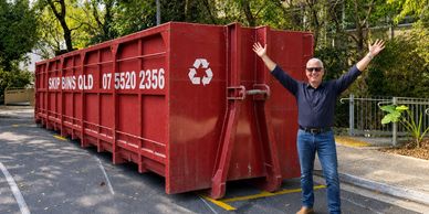 Mark Gardner beside a 55m³ Super Bin, with Skip Bins QLD branding. Edited photograph.