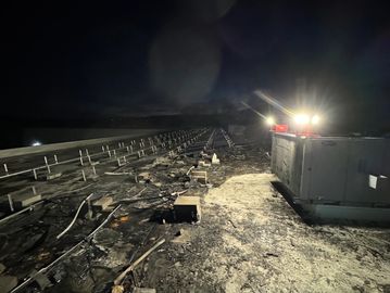 Burned solar array under inspection after equipment failure.