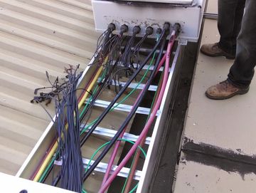 Technician repairing solar rooftop wiring for emergency service.