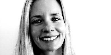 Black and white close-up of a smiling woman with long hair.