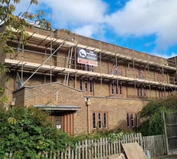 Brick building under construction with scaffolding.