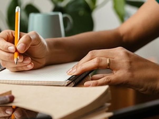A book reviewer reading a Christian book and taking notes.