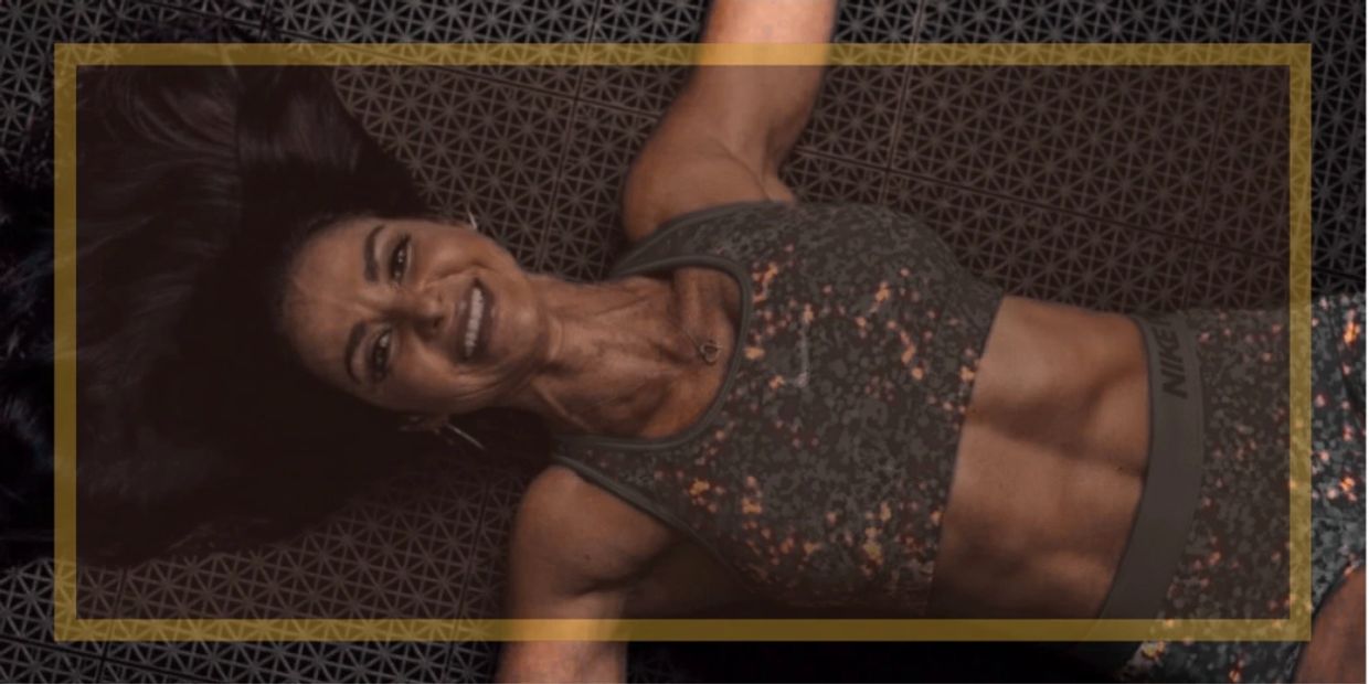 Fit woman in sportswear smiling on exercise mat.