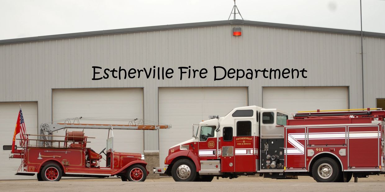 Two red fire trucks parked in front of Estherville Fire Department.