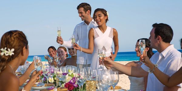 Beach wedding reception. Toast being made to the happy couple