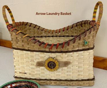 Handwoven Arrow Laundry Basket with decorative flower and sturdy handles.