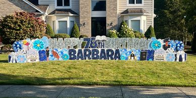 A large yard sign saying Happy 78th Birthday Barbara in front of a house.