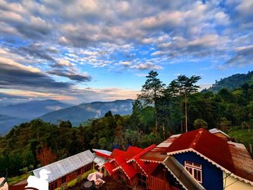 Scenic mountain view with colorful rooftops and a vibrant sky.
