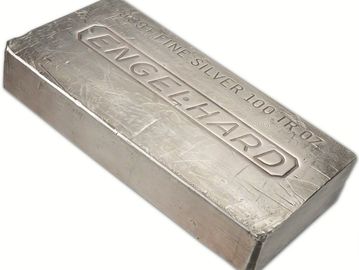 A 100 oz silver bar stamped with 'ENGELHARD' and purity details.