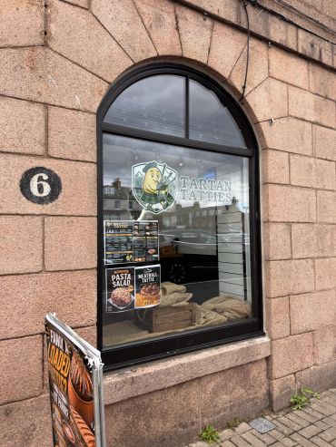 Window of Tartan Tatties shop with wall number 6.