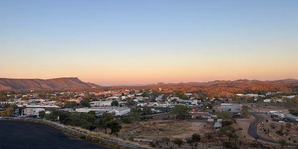 Sunset over a small town with mountains in the background.