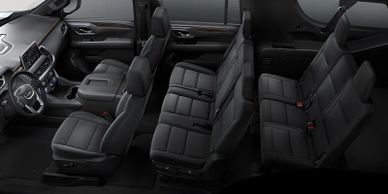 Interior of a modern SUV showing three rows of black seats and dashboard.