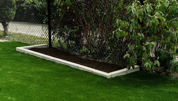 Front yard garden with interlock retaining wall and artificial grass in Riverside South