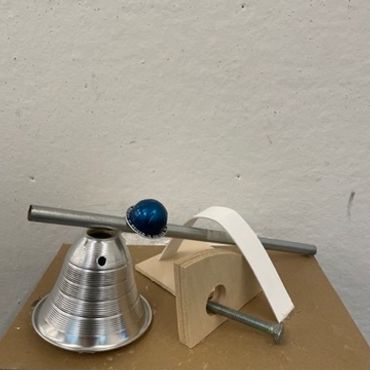 Simple homemade balance scale with a blue marble.