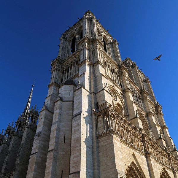 View of a gothic cathedral tower against a clear sky.