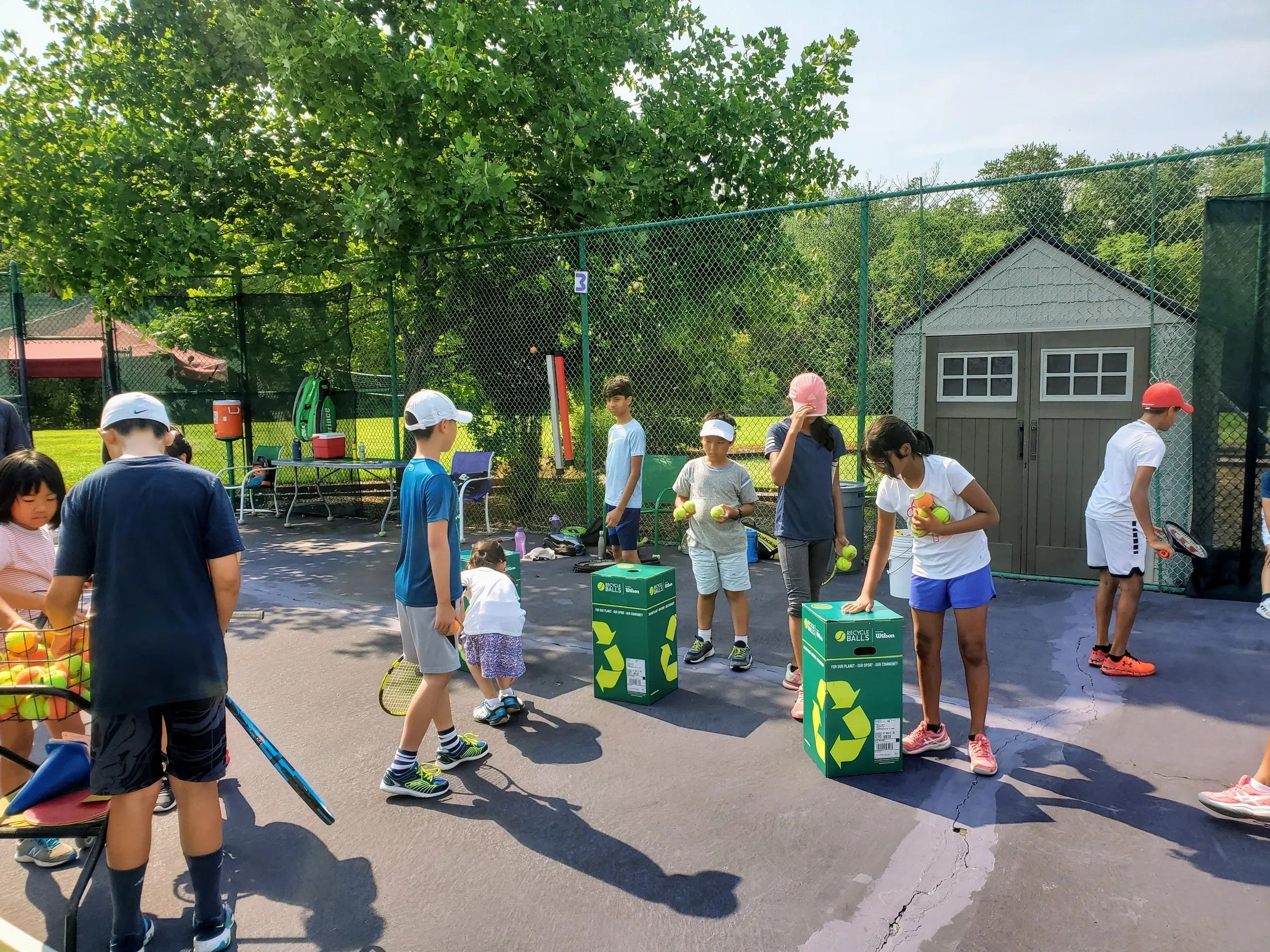 Summer Camp collecting tennis ball and recyclables around the tennis courts and field around us.