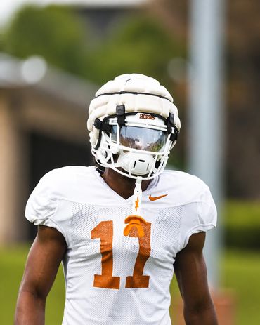 Football player in white uniform and helmet during practice.