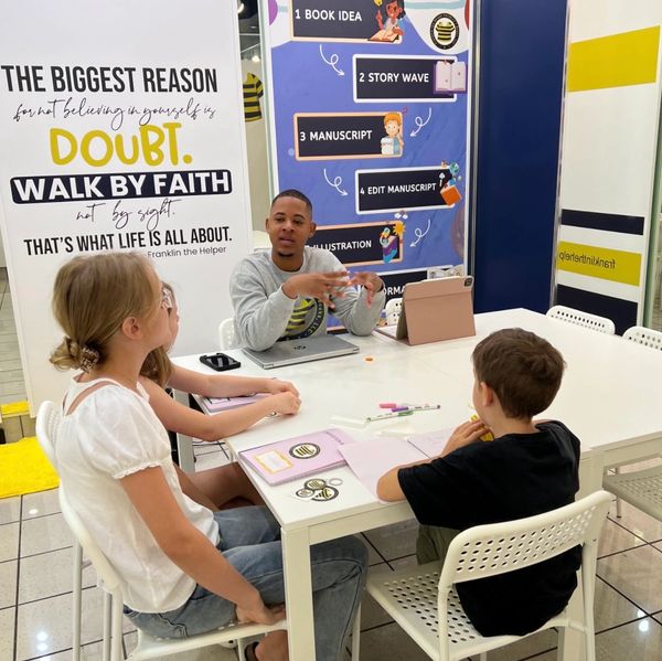 Teacher engaging children in a creative classroom setting with motivational quotes.
