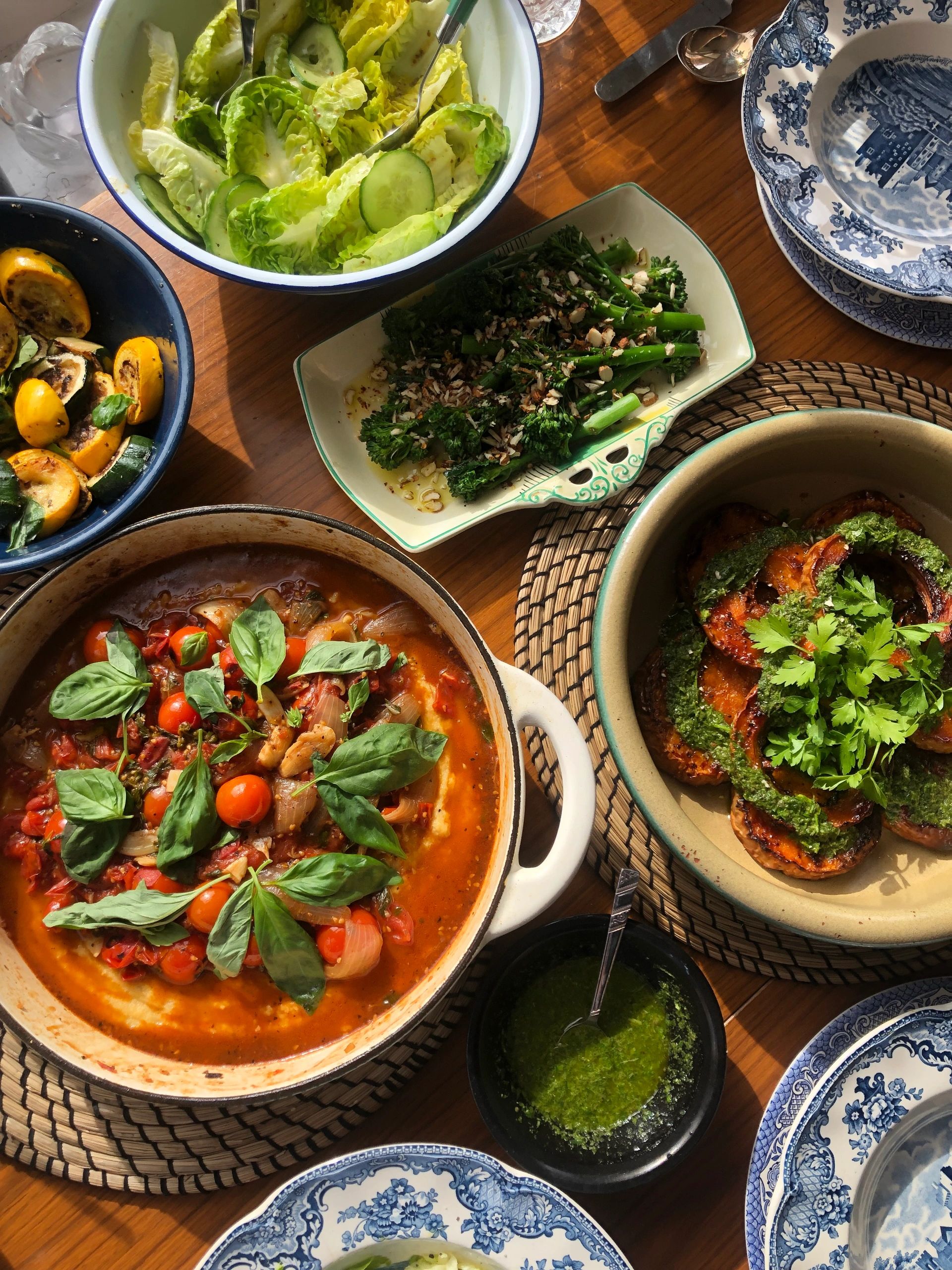 A vibrant spread of fresh vegetable dishes on a wooden table.