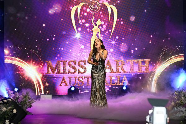 Contestant singing on stage at Miss Earth Australia.