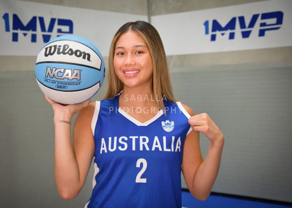 Female basketball player holding a ball, wearing Australia jersey.