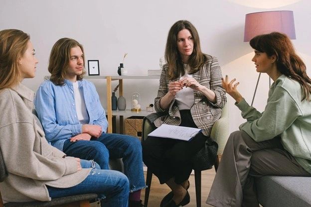 A female psychologist discussing problems during a group therapy session