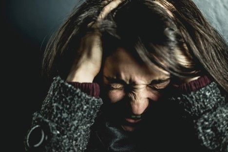 Stressed woman holding her head, Understanding PTSD