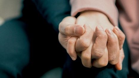 Two people holding hands, Offering support for PTSD, handling someone with PTSD.