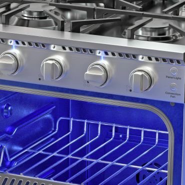 Close-up of a modern oven with blue interior light on.