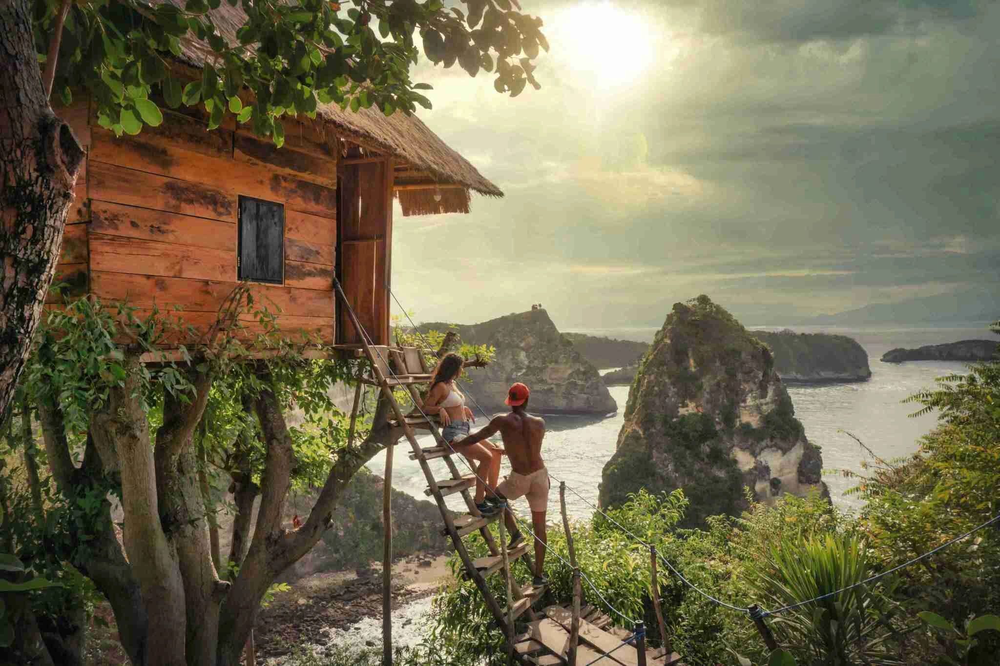 Couple in a Bali treehouse surrounded by lush greenery, enjoying a romantic moment in a serenity.