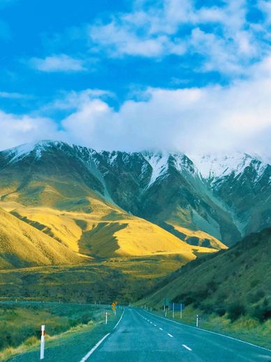 Scenic road winding through mountains in New Zealand, ideal for a romantic road trip adventure.