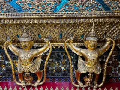 Ornate golden statues with intricate designs on a decorative wall.